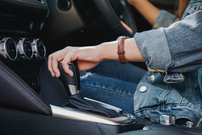 Midsection of woman holding gearshift