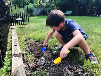 Full length of boy gardening at yard