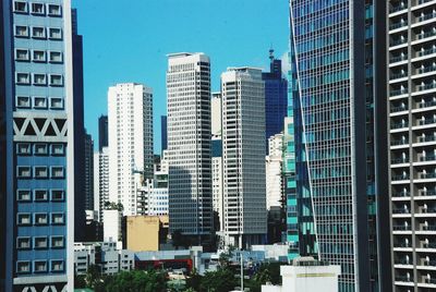 Buildings in city against blue sky