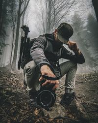 Man photographing on field in forest