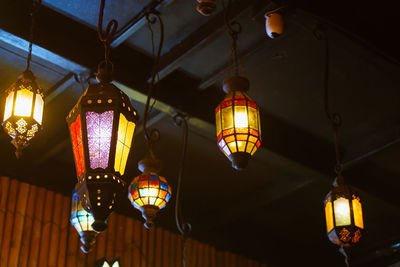 Low angle view of illuminated pendant lights hanging from ceiling