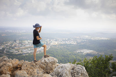 Man from behind standing on the edge of the mountain and watching a landscape. hiking concept. 