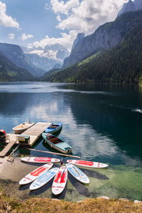 Boats moored on lake against mountains