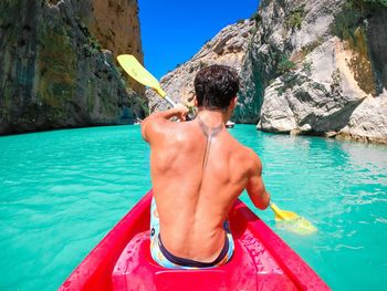 Shirtless man swimming in sea