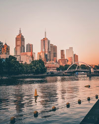 View of river and buildings against clear sky