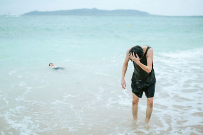 Full length of young woman walking at beach