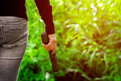 Midsection of man holding plant on field