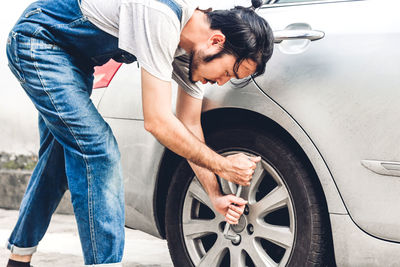 Man repairing car outdoors