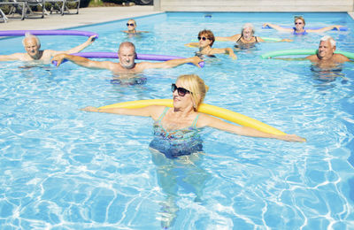 Group of seniors doing water gymnastics in pool