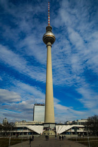 Low angle view of communications tower against cloudy sky