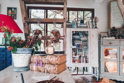 Flower vase by books on table at home