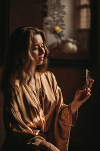 Young attractive female sitting with butterfly on her hand