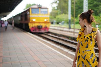 Young woman standing on railroad station platform