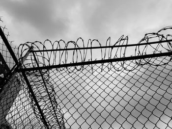 Low angle view of chainlink fence against sky