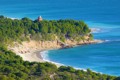 High angle view of trees and sea against blue sky