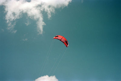 Low angle view of person paragliding against sky