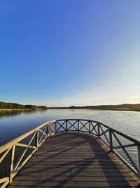 Scenic view of lake against clear blue sky