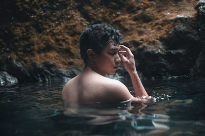 Portrait of shirtless man in swimming lake