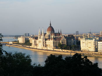 Buildings in city at waterfront houses of parliament, budapest, hungary