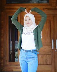 Portrait of smiling girl standing against wall