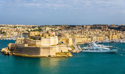 Panoramic view of sea and buildings against sky