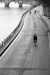 Rear view of people walking on bridge in city