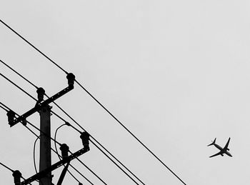 Low angle view of power lines against clear sky