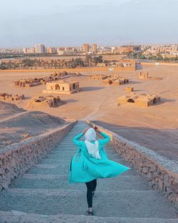 Rear view of woman walking on road