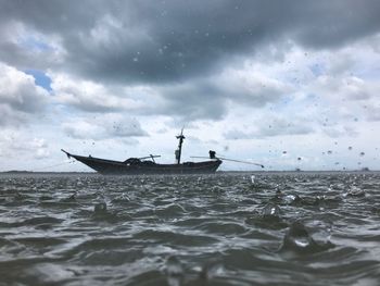 Fishing boat in sea against sky