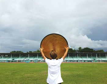 Rear view of girl playing on field