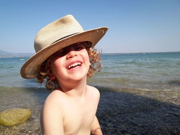Portrait of happy young woman in hat on beach