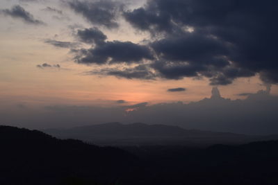 Scenic view of silhouette mountains against dramatic sky