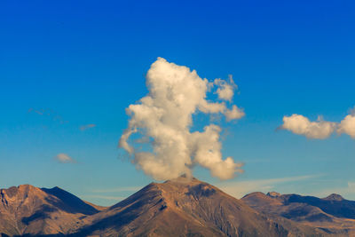 Scenic view of snowcapped mountains against blue sky