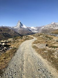 Scenic view of mount matterhorn snowcapped mountains in the distance against clear blue sky