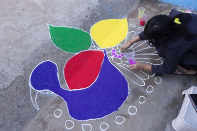 Tribal people drawing rangoli on the eve of diwali