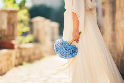 Woman holding bouquet standing outdoors