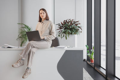 Portrait of young woman using digital tablet while sitting at home