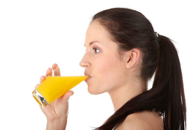 Portrait of young woman holding ice cream over white background