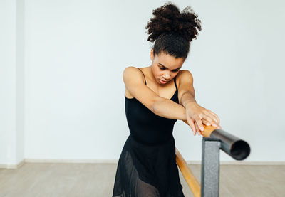 Young woman dancing by railing in studio