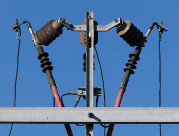 Low angle view of machine part against clear blue sky