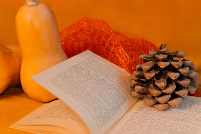 Close-up of orange and book on table