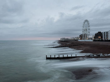 Scenic view of sea shore with ferris wheel