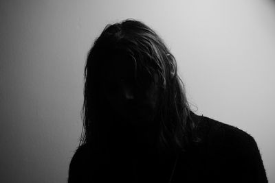 Portrait of woman standing against wall