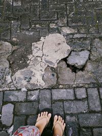 Low section of woman standing on footpath