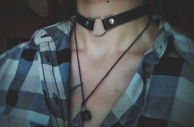 Midsection of woman wearing choker and necklace