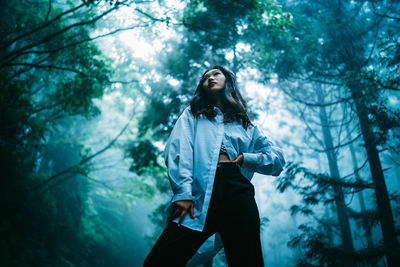 Young woman standing in forest