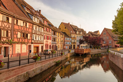 Houses by river against sky