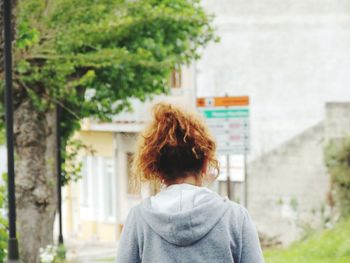 Rear view of woman standing against building