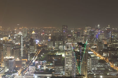 High angle view of illuminated buildings against sky at night