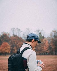 Rear view of man on field against sky